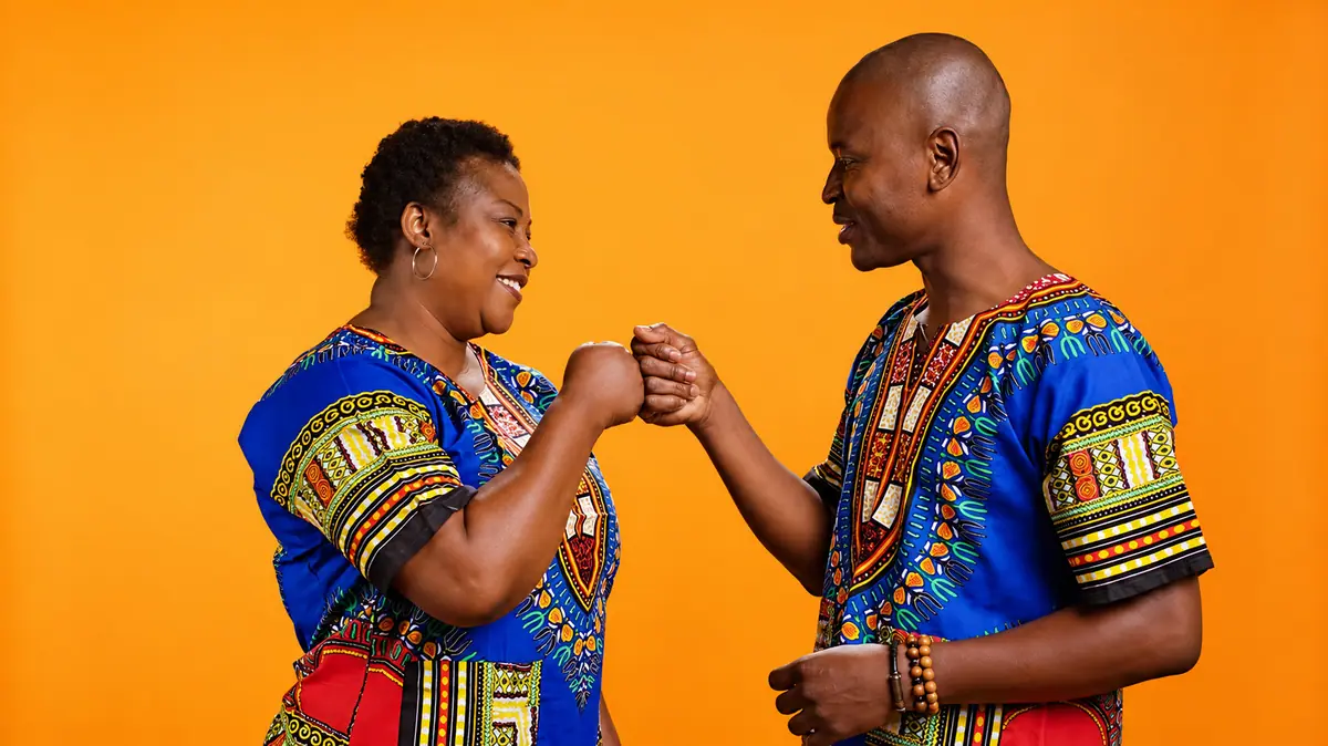Two people smiling and greeting one another with a fist bump